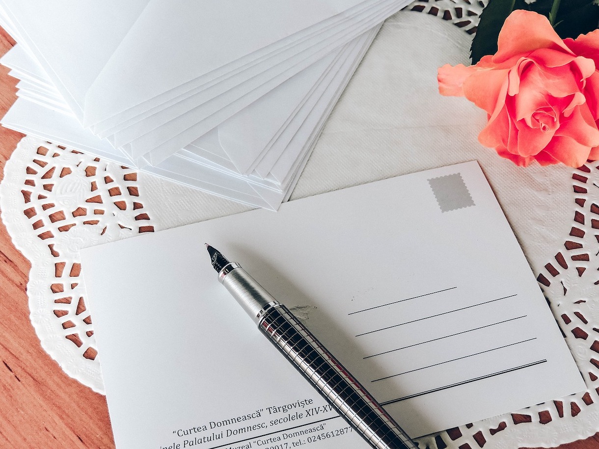 Pen resting on postcard on table