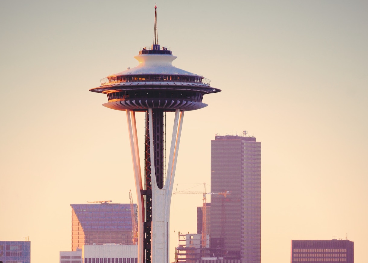 Photo of the space needle against a purple and orange sky.